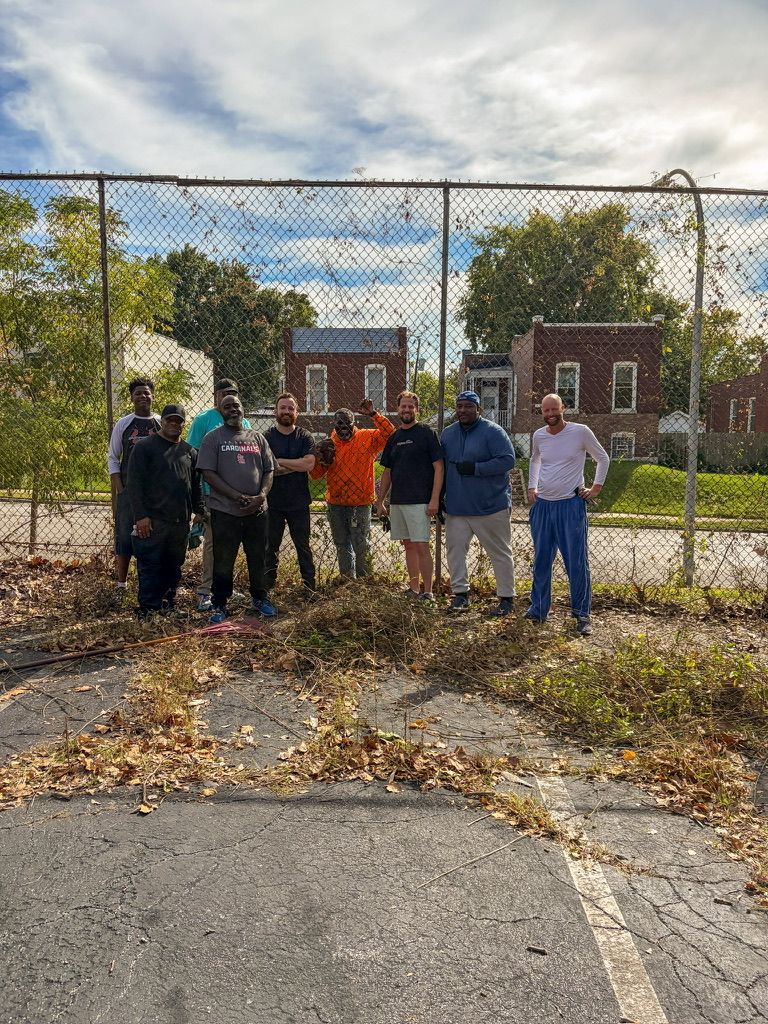 Nine neighbors standing together by the fence after clearing brush from the lot