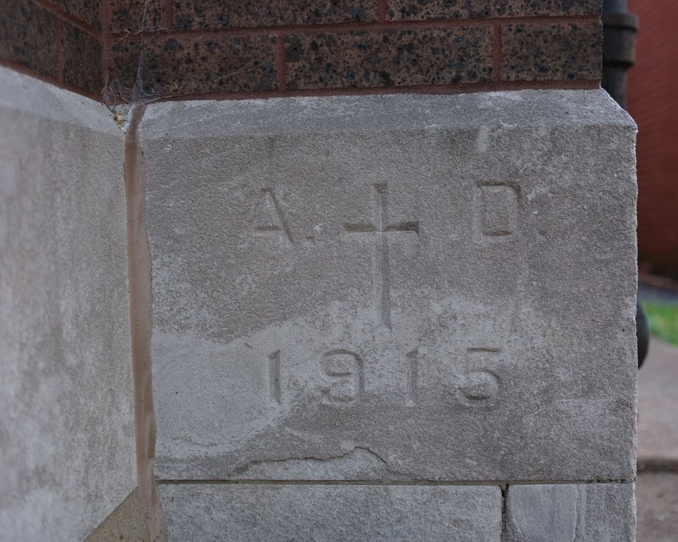 Limestone cornerstone carved A.D. 1915 with a cross