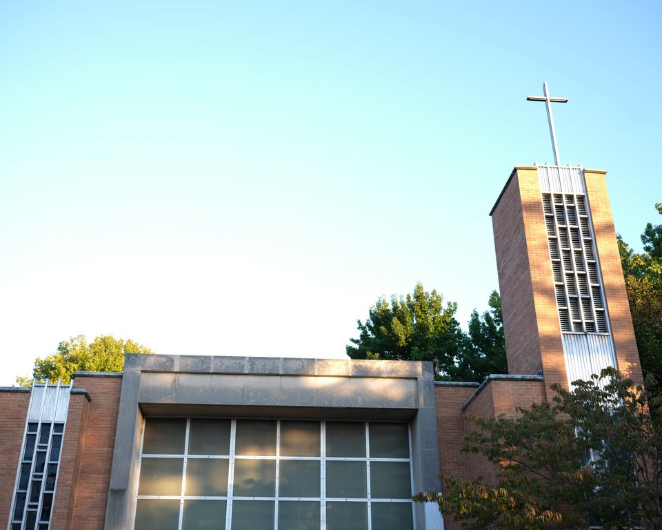 The brick church at 3201 Itaska with its bell tower and cross against a clear evening sky